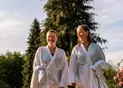 Et par i badkåber slapper af i liggestole i en spa omgivet af natur