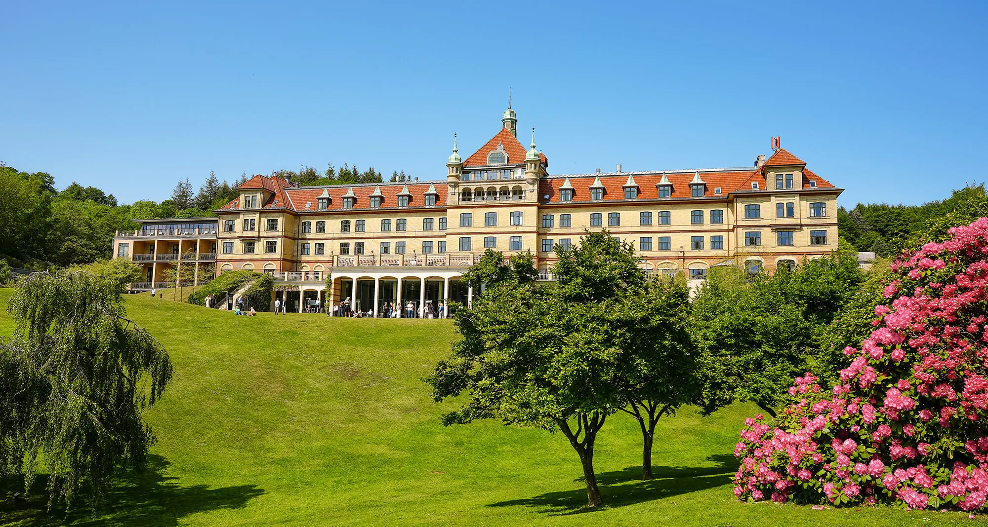 Hotel Vejlefjord set fra parken i solskinsvejr