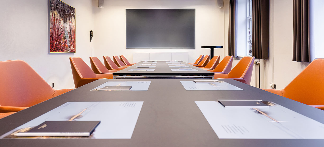 Bredt bord med cognacfarvede stole omkring