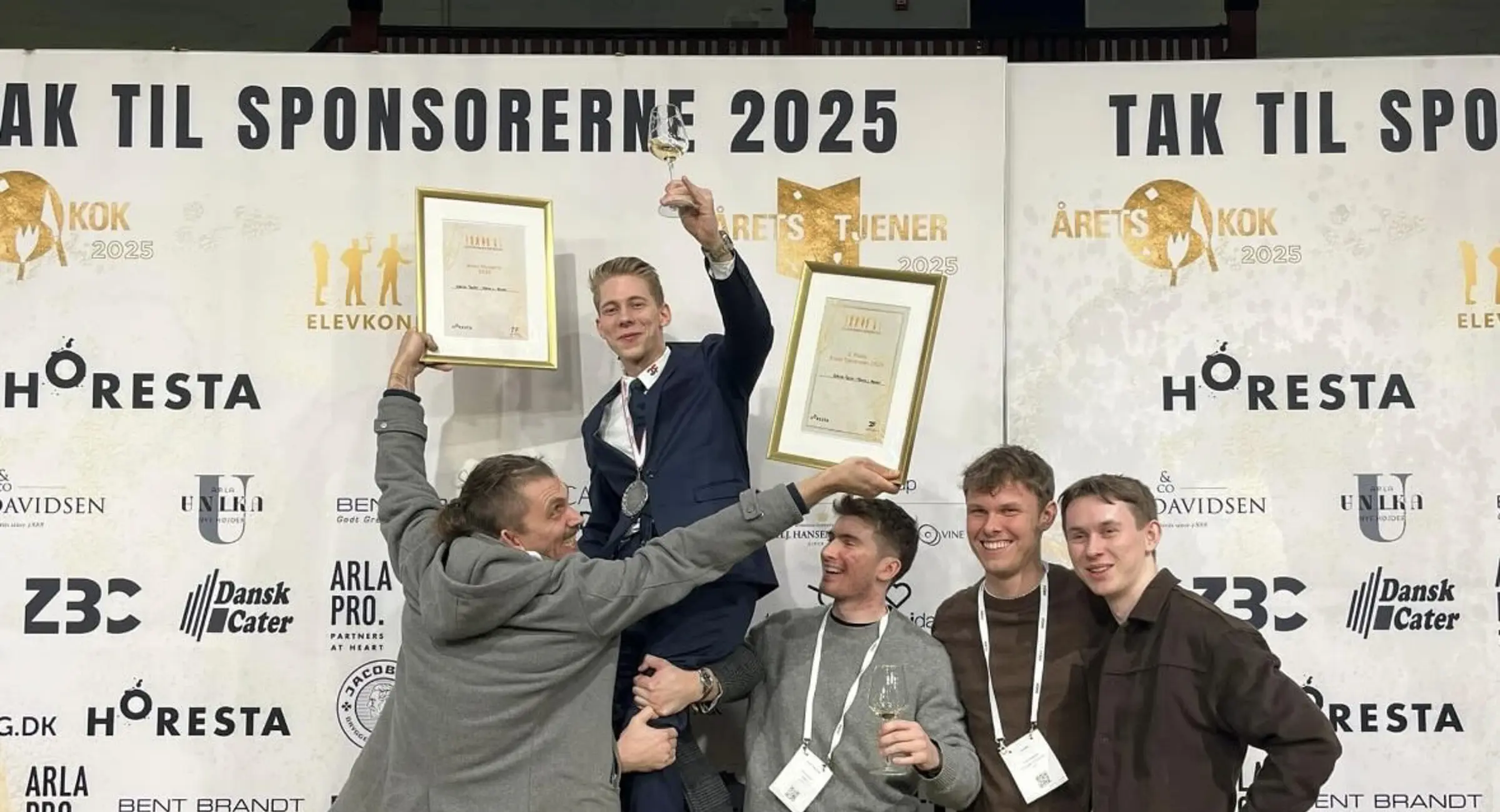 Tjenerelev Marcus bliver løftet af kolleger der fejrer hans sølvmedalje