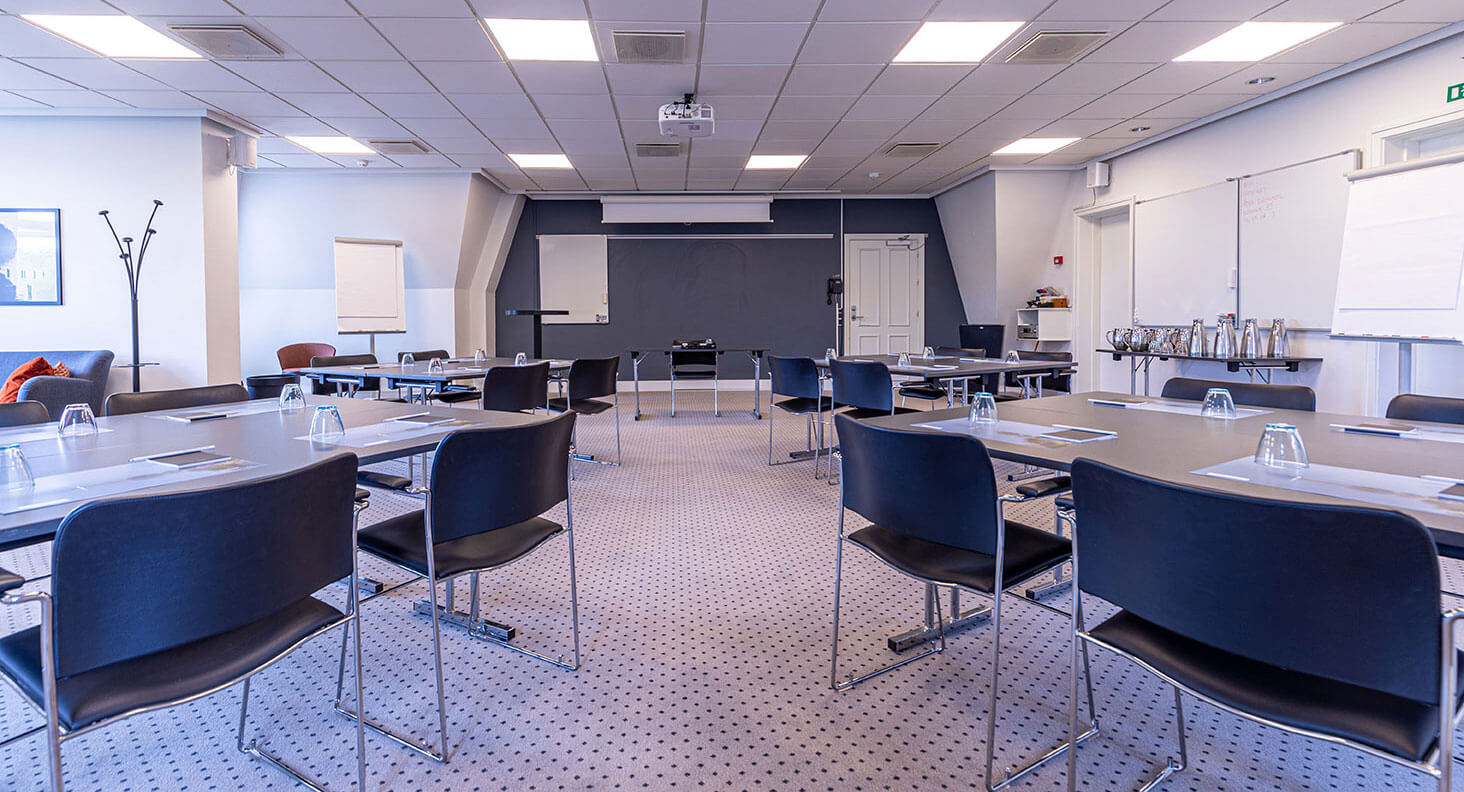Konferencelokale opstillet i grupper op mod væg med tavler