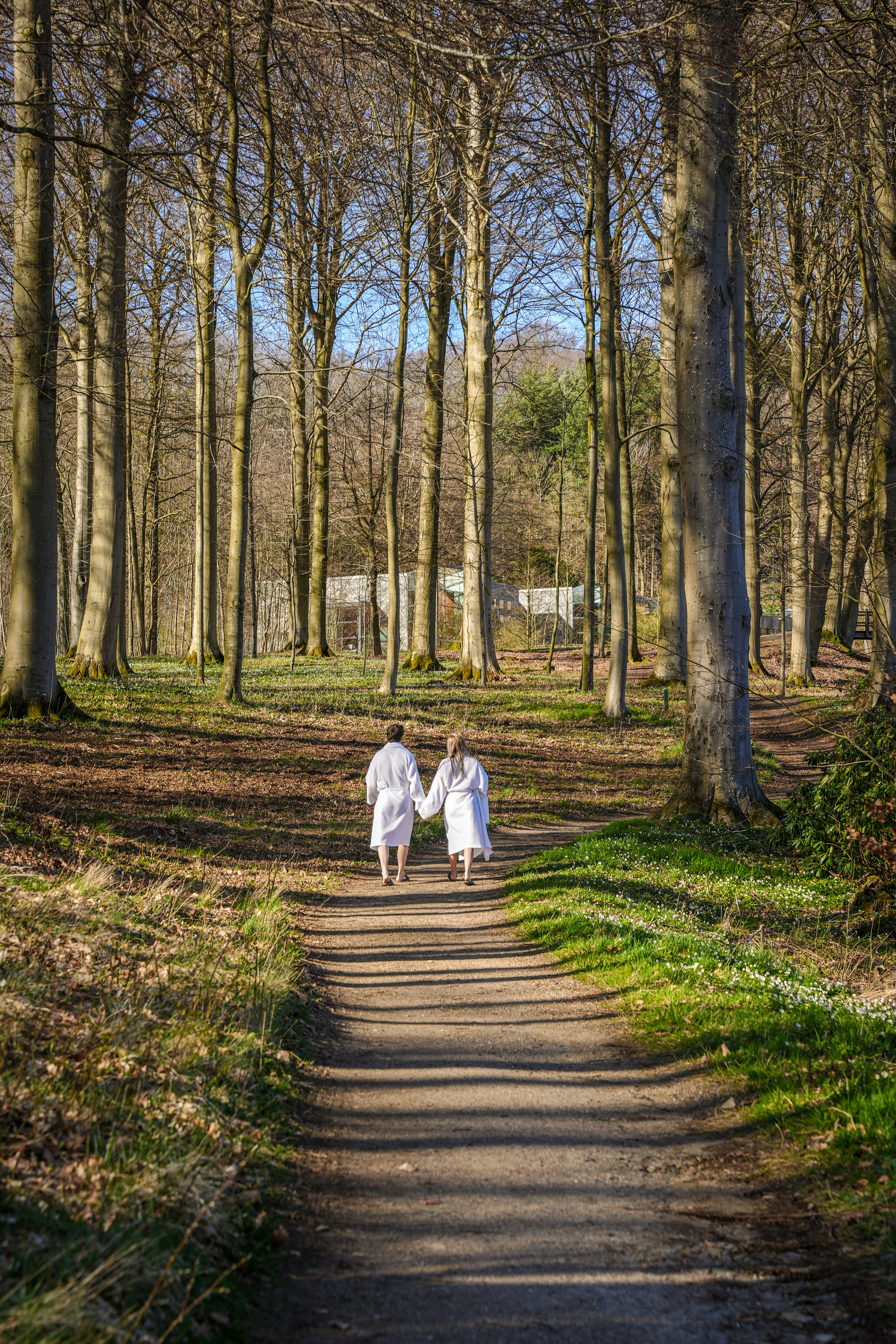 Par der går i badekåber gennem skoven