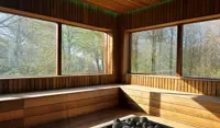 En sauna med skov uden for vinduerne