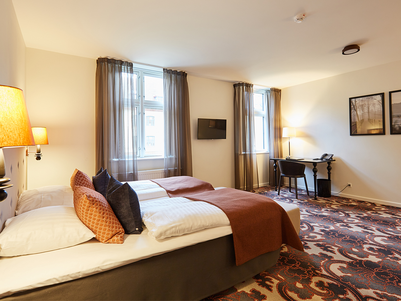 Et hotelværelse med varmt lys og dobbeltseng