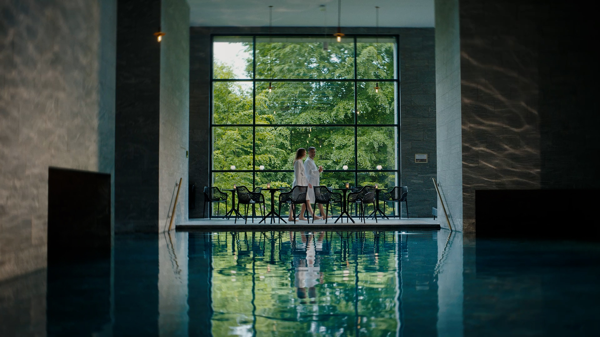 Et smukt stort termisk bad med lysindfal og grønt uden for de store vinduer