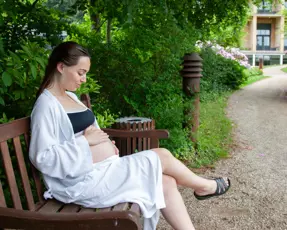 Gravid kvinde siddende på bænk
