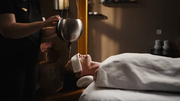 En varm og blid oliestrøm der render nedover pande og hårbund