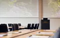 Konferencelokale med talerstol, stole og borde dækket op til konference