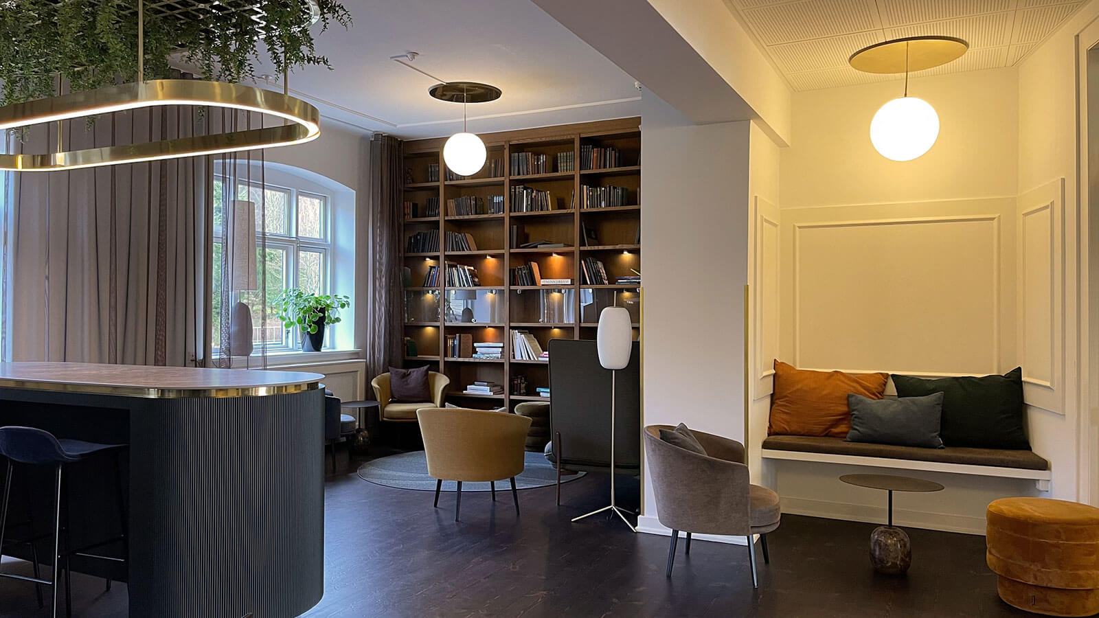 Hyggeligt rum indrettet med stor reol og loungemøbler