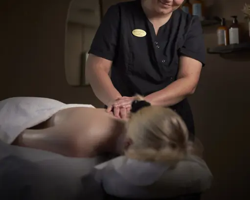 En kvinde ligger og får massage af en terapeut