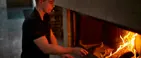 En mand er ved at tænde op i en pejs