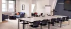 Konferencelokale med stort bord og hyggelige loungemøbler i baggrunden