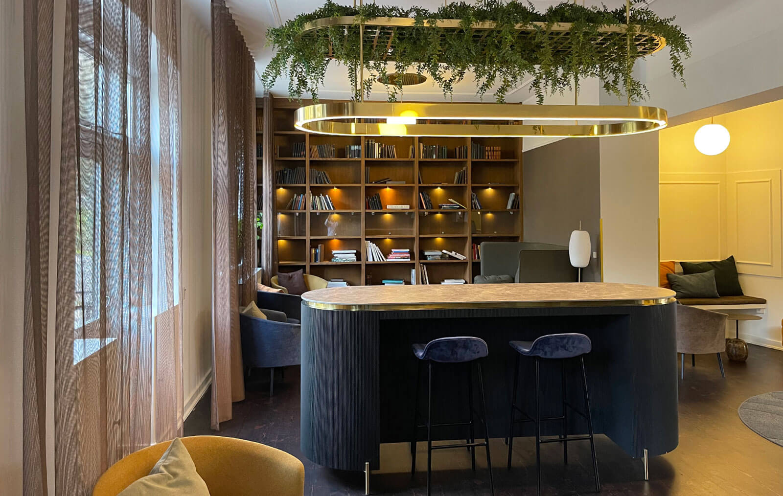 Hyggeligt rum indrettet med stor reol og loungemøbler