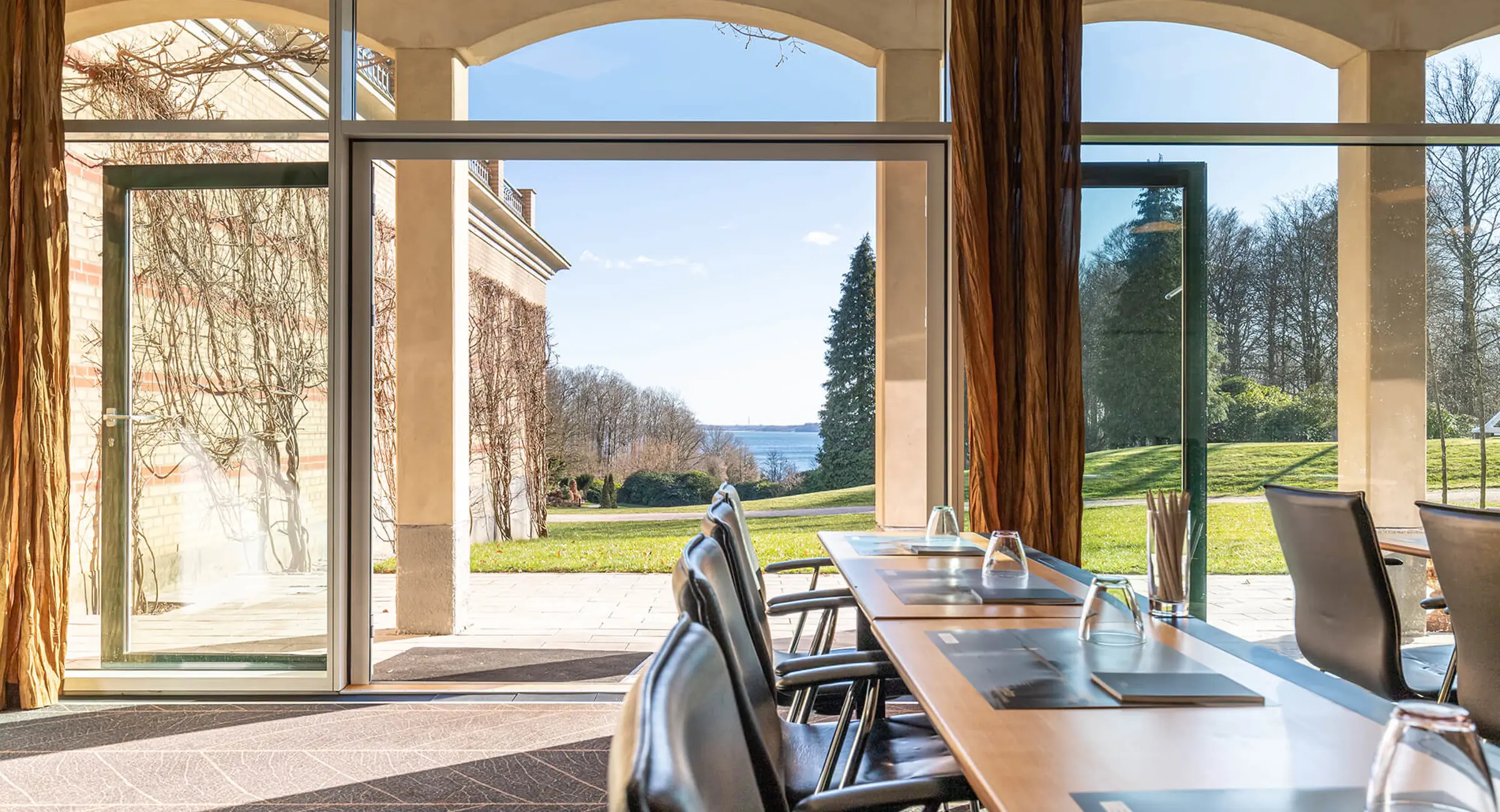 Konferencesal med med udsigt til en park og Vejle Fjord