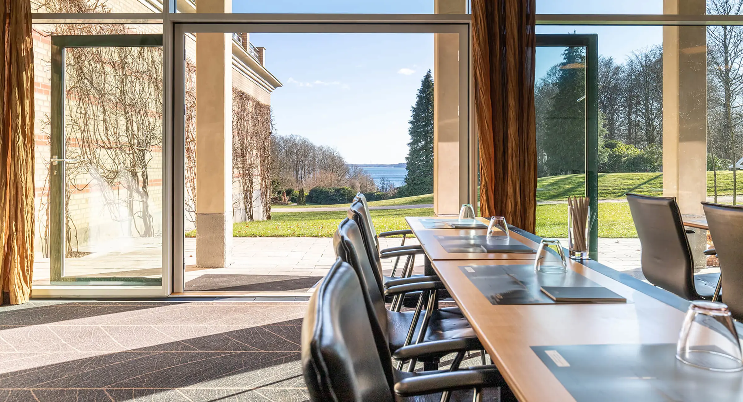 Konferencesal med med udsigt til en park og Vejle Fjord