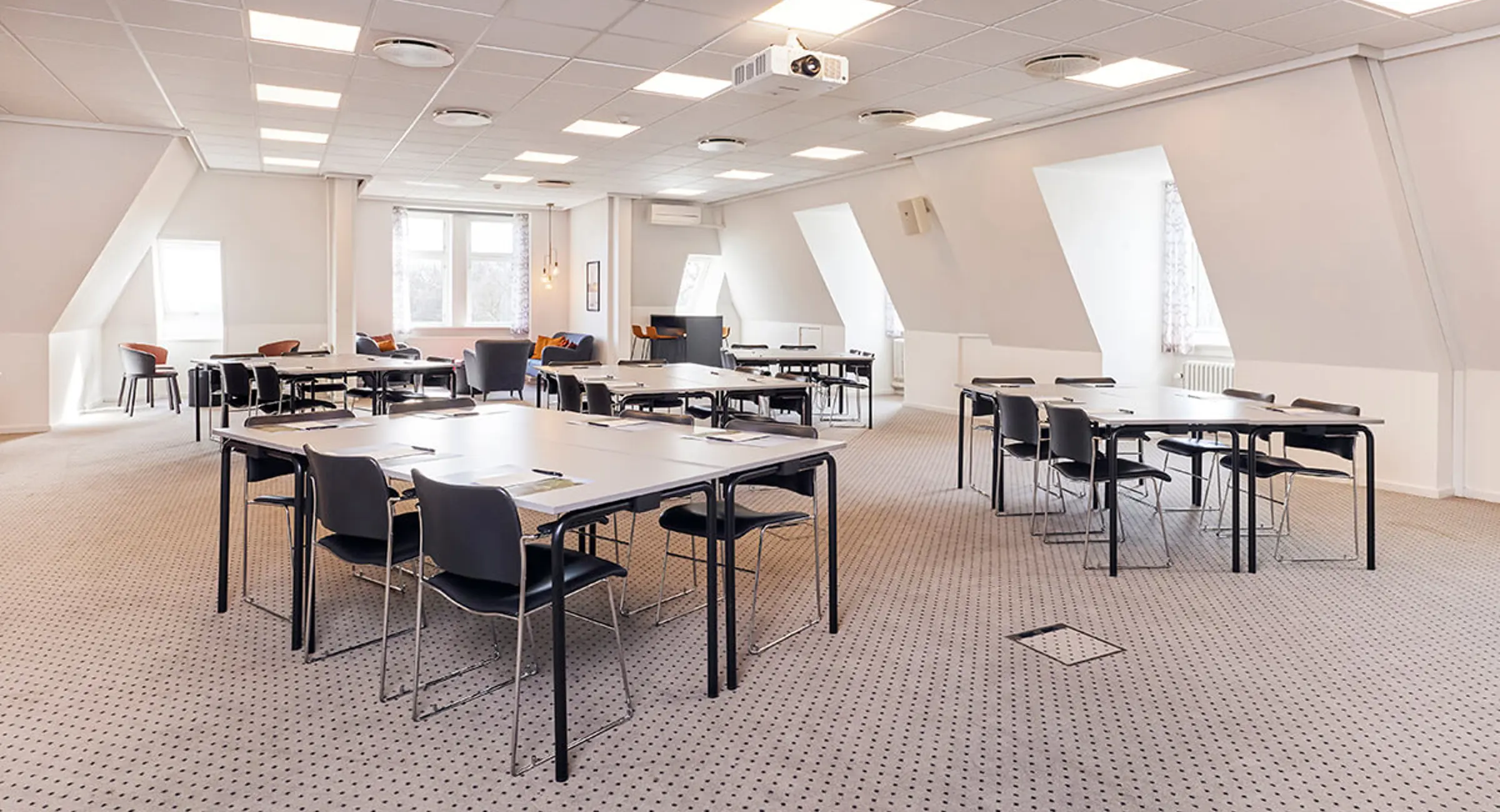 Konferencelokale hvor bordene er opstillet i grupper