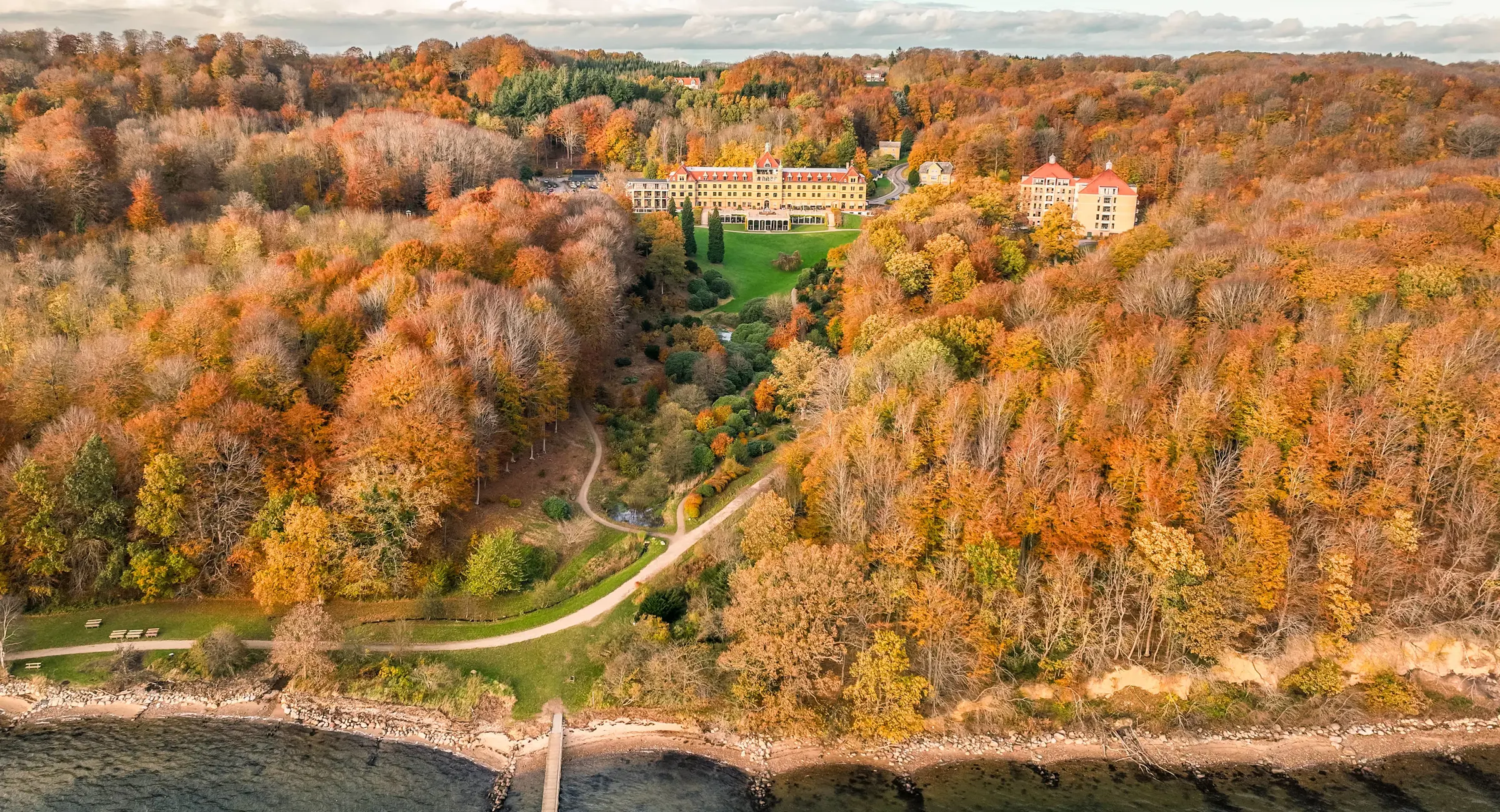 Udsigt over hotel, park og fjord i efteråret