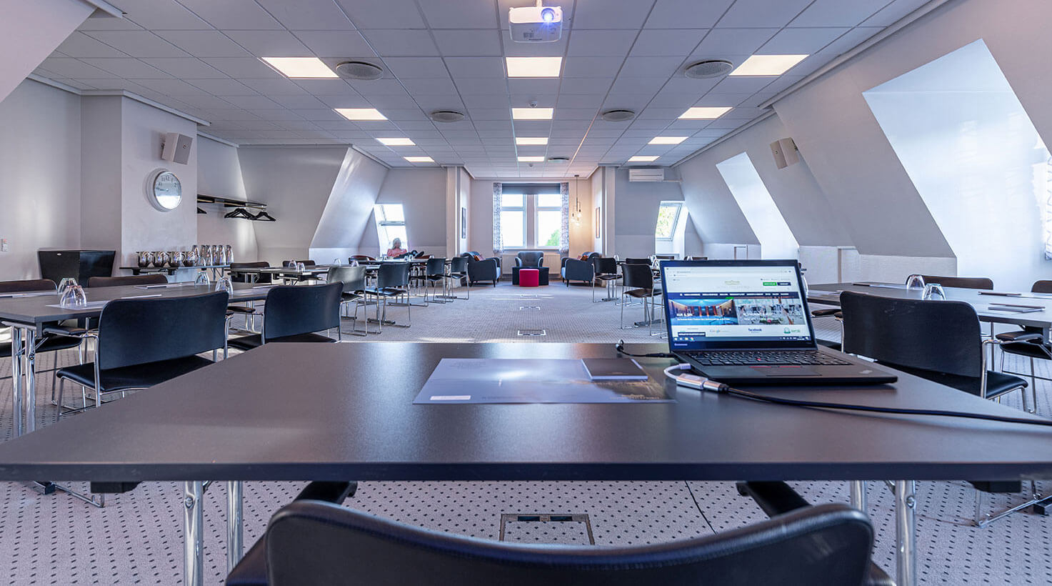 View gennem et mødelokale med gruppeborde