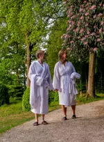 Kvinde er på vej ned i en pool i et spaområde med liggestole