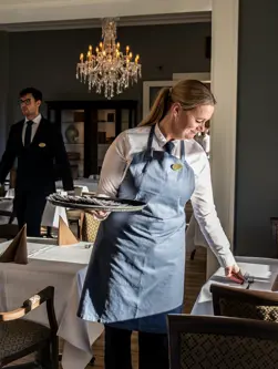 Tjener dækker bord i Brasseriet på Hotel Vejlefjord
