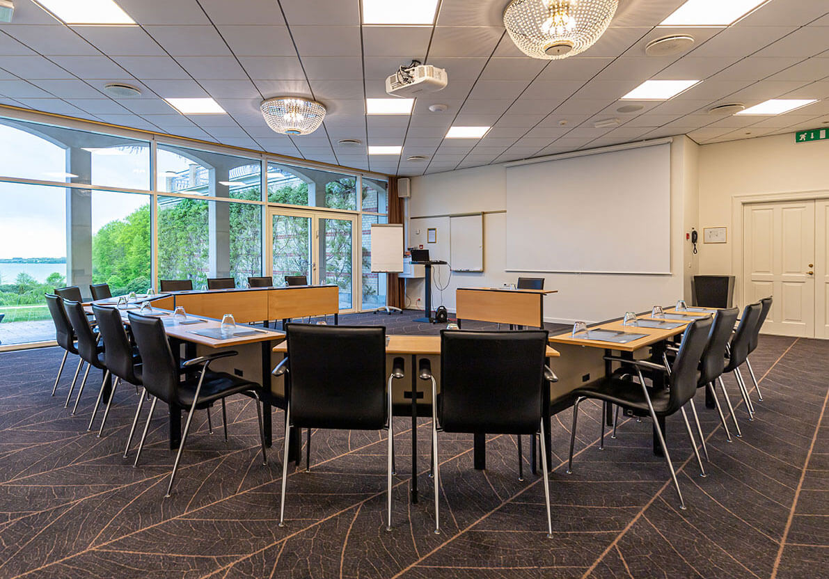 Et mødelokale med AV-teknik opstillet i u-bord 