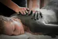 Hænder der masserer ler ind på overkroppen af en kvinde