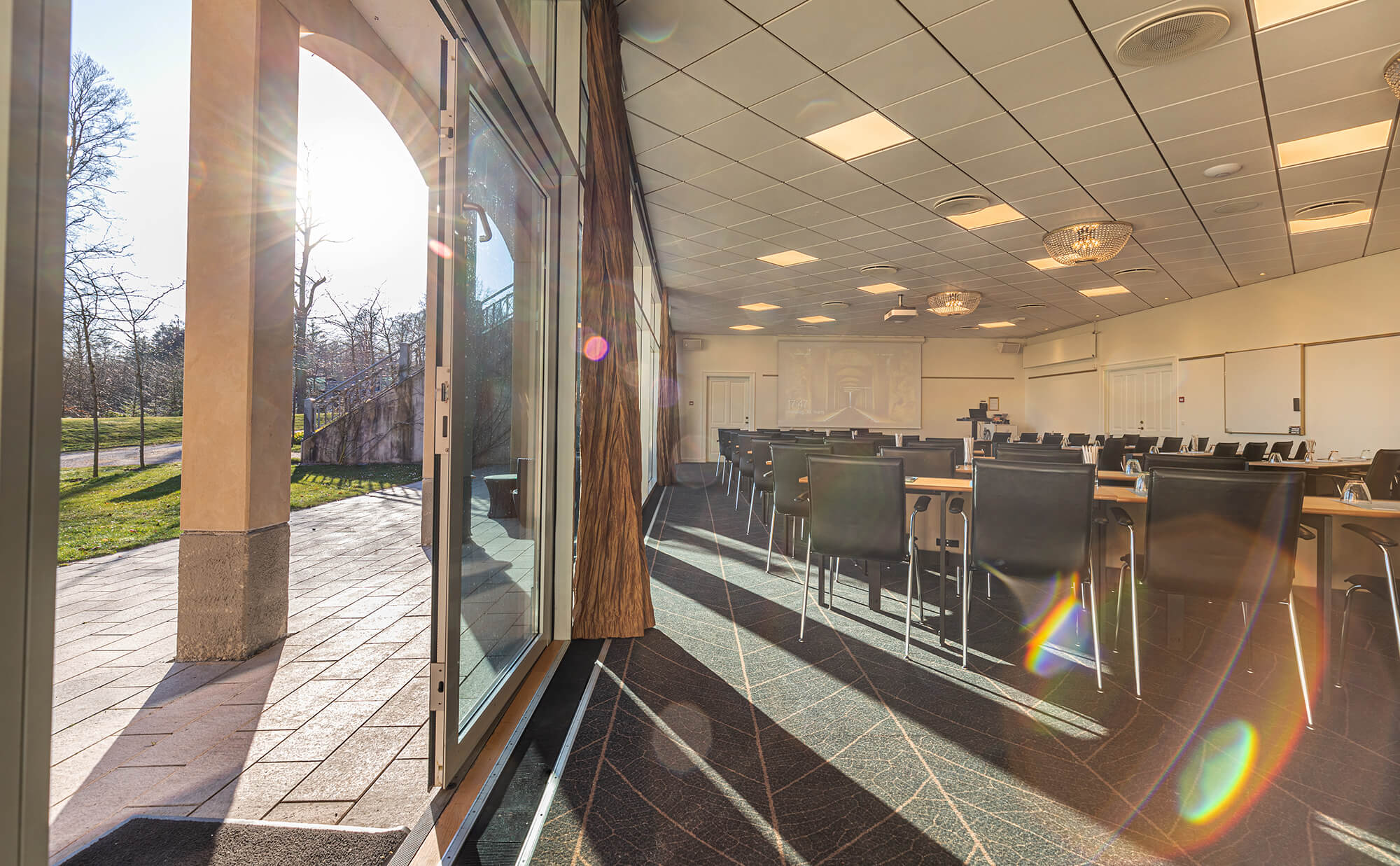 Konferencesal opstillet til møde - men også kig ud på en overdækket terrasse