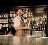 En bartender holder en shaker i en bar