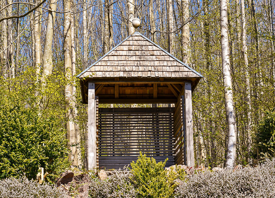 Et fint lysthus bygget i træ i en skov ved Vejlefjord som kalder det Kys-mig-straks-huset